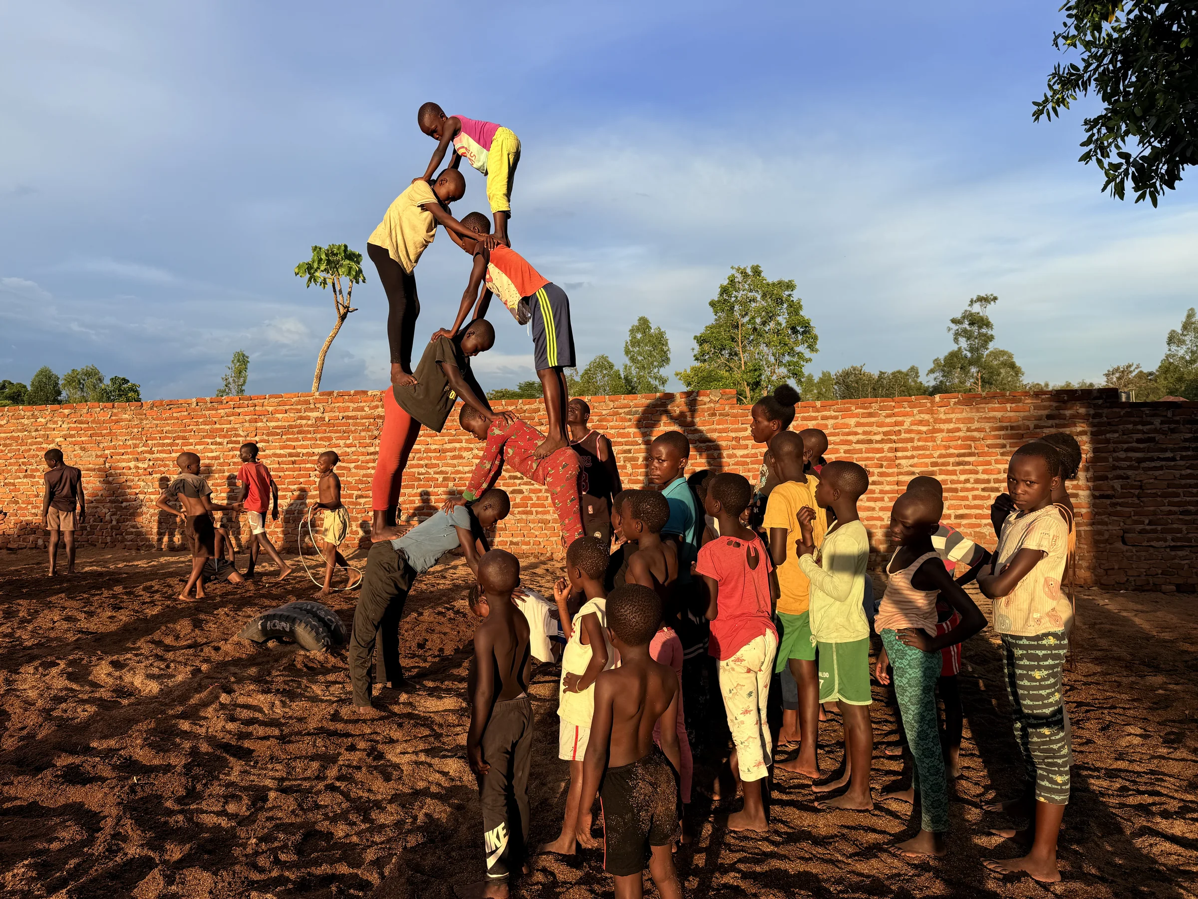 Young Clon Circus Uganda acrobats performing a human pyramid at their training ground