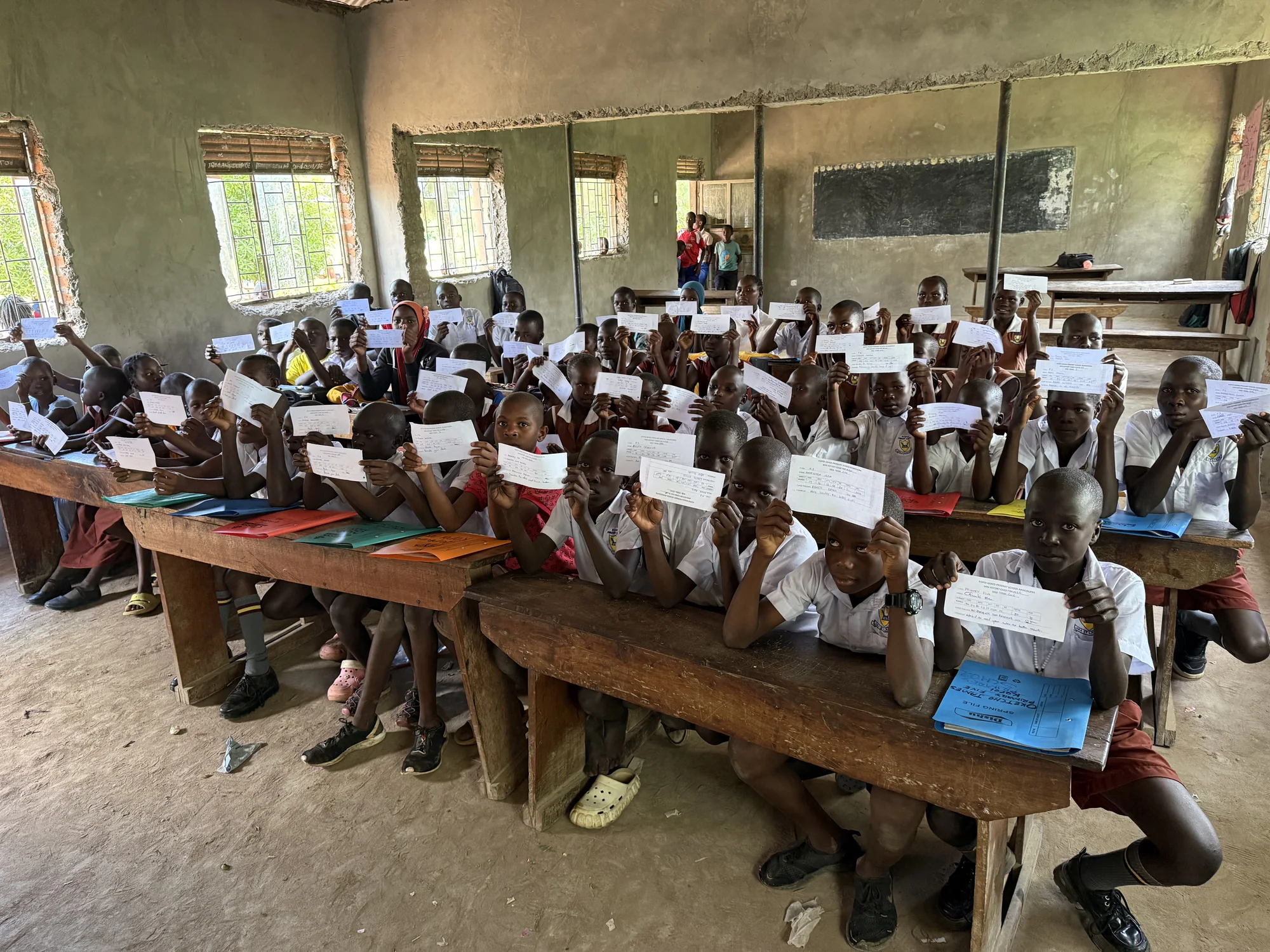Children showing their completed school work in class