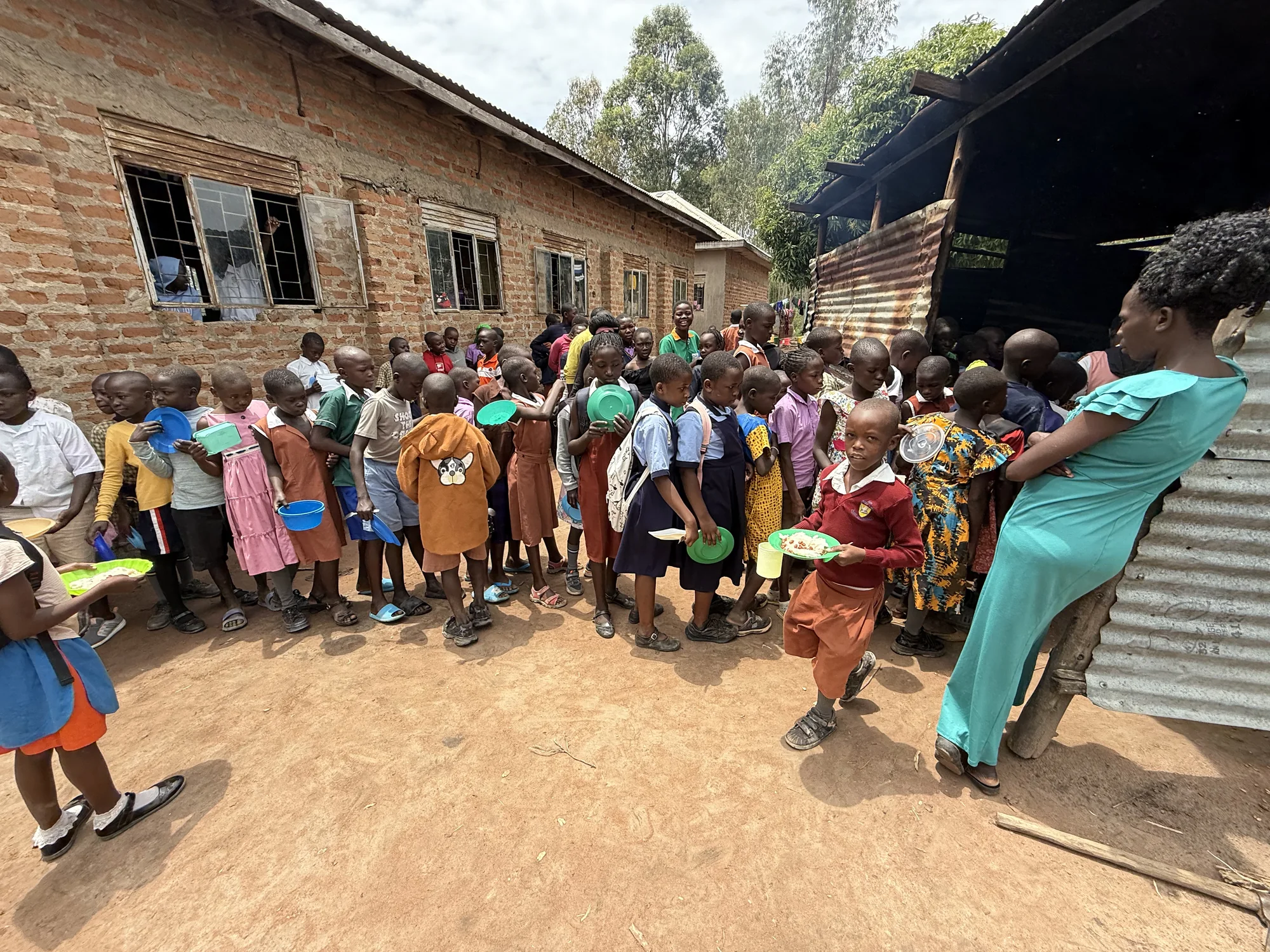 Members of the Clon Circus Uganda community come together around meal support.