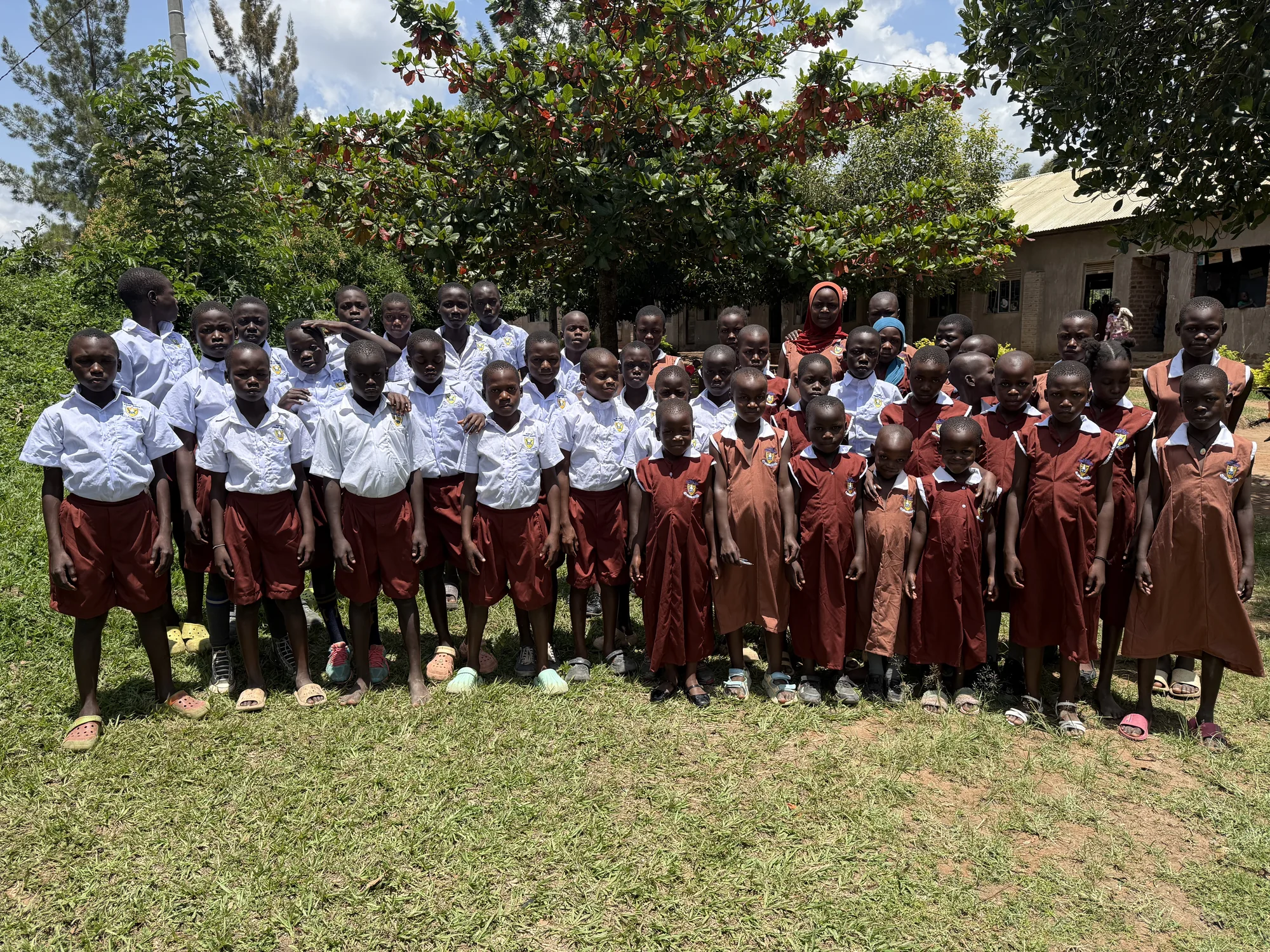 Children from the Clon Circus Uganda community gathered in a school setting.